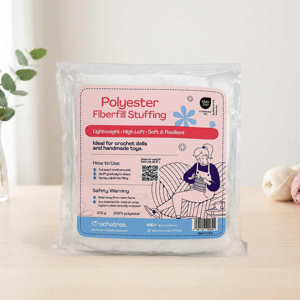 Crochetree polyester fiberfill stuffing 100 g bag on a cream table with yarn