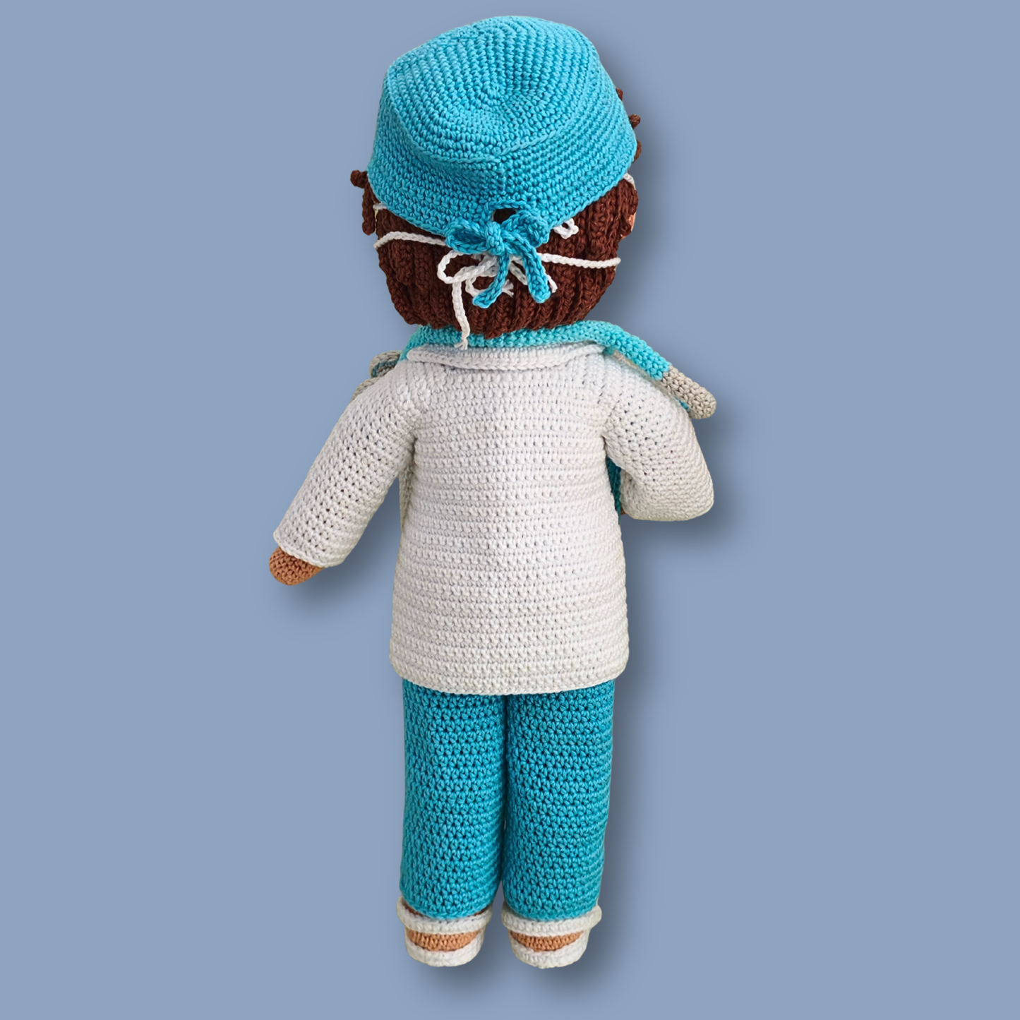 Back view of Dr. Thomas crochet doll showing tied scrub cap over brown hair and white lab coat