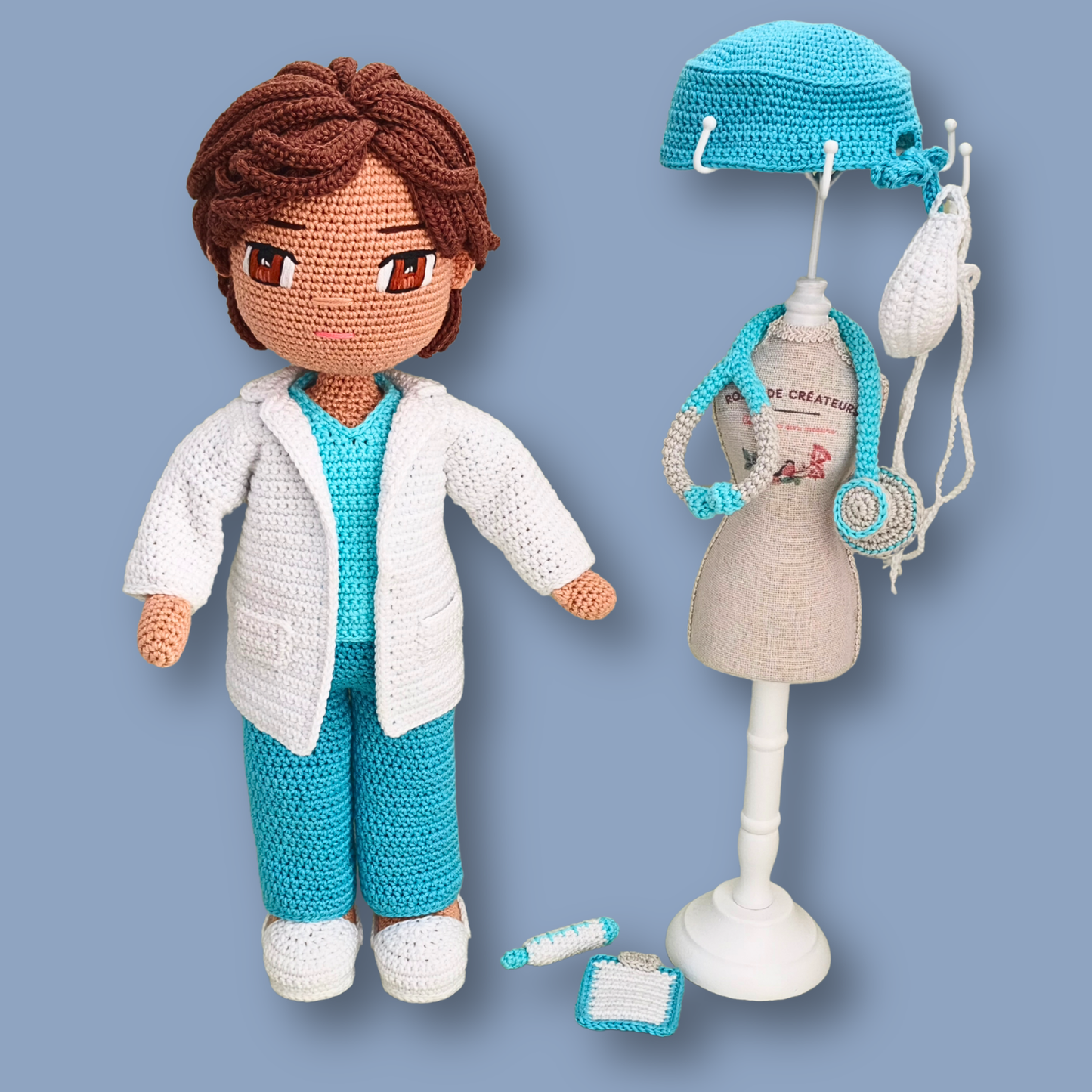 Doctor crochet doll pattern - Dr. Thomas next to a mannequin displaying scrub cap, face mask, and stethoscope