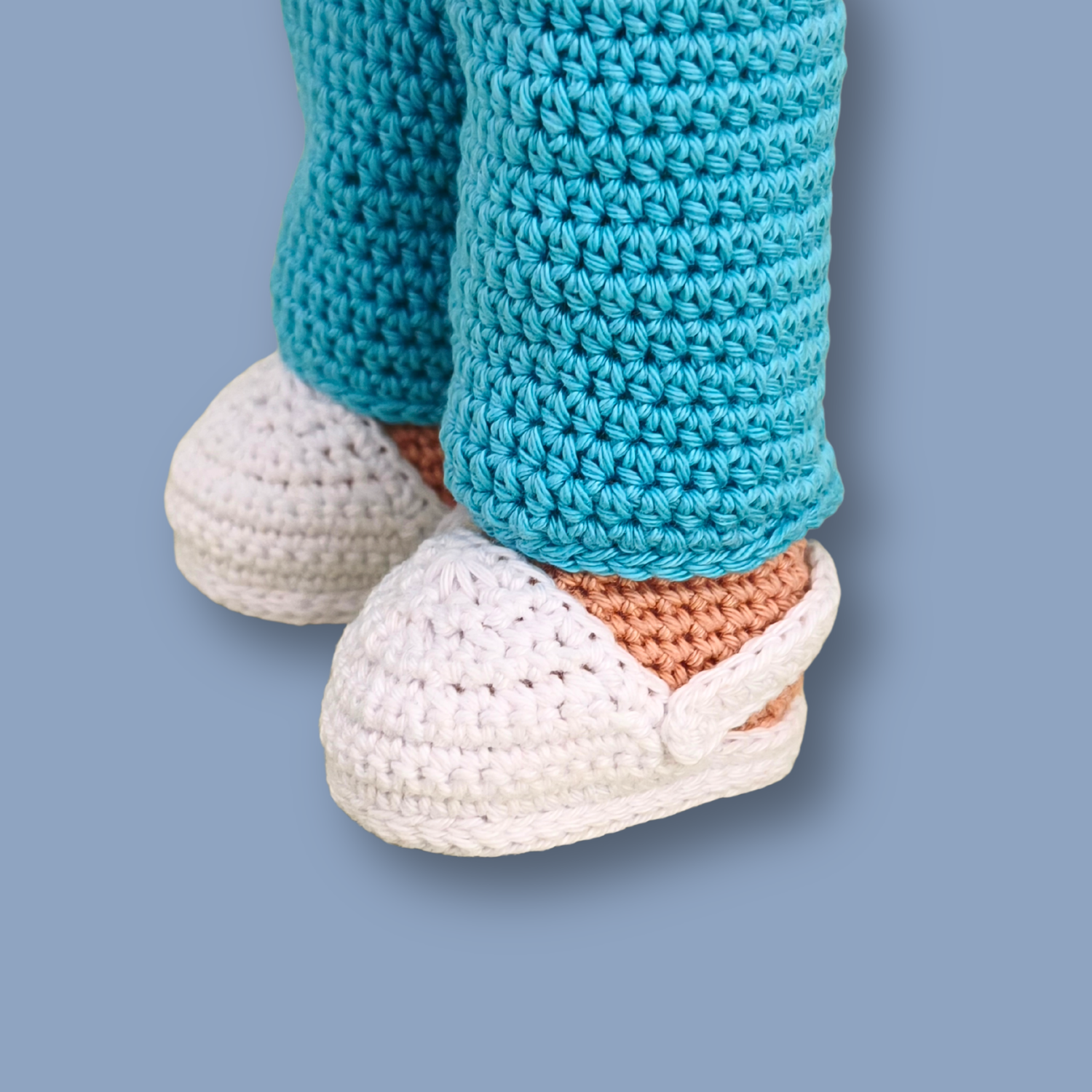 Close-up of Dr. Thomas crochet doll's white sneakers and turquoise pants - amigurumi doll pattern detail