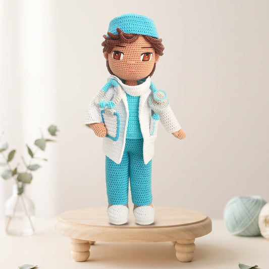 Dr. Thomas crochet doll pattern - doctor doll in scrub cap, white lab coat, and turquoise scrubs on a wooden stand